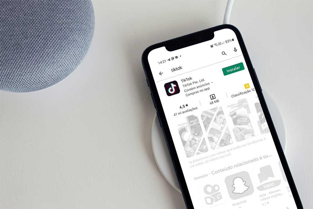 Como baixar o aplicativo Tik Tok : Celular sob uma superf&iacute;cie tendo a mostra a tela de instala&ccedil;&atilde;o do tik tok