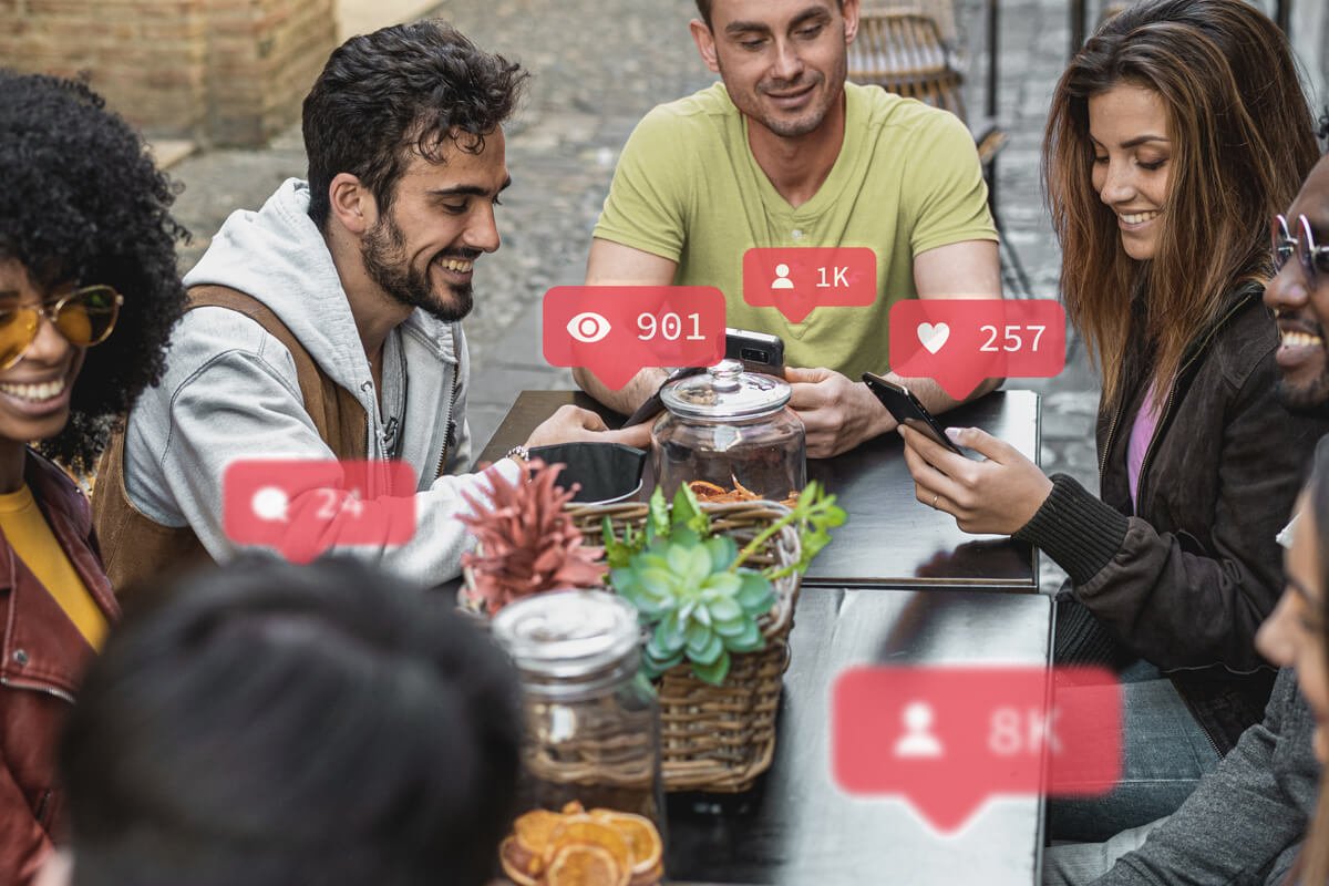 Grupo de pessoas conectadas e engajadas atrav&eacute;s das comunidades virtuais, sentadas em uma mesa compartilhando di&aacute;logos e ideias. Foto: @Freepik