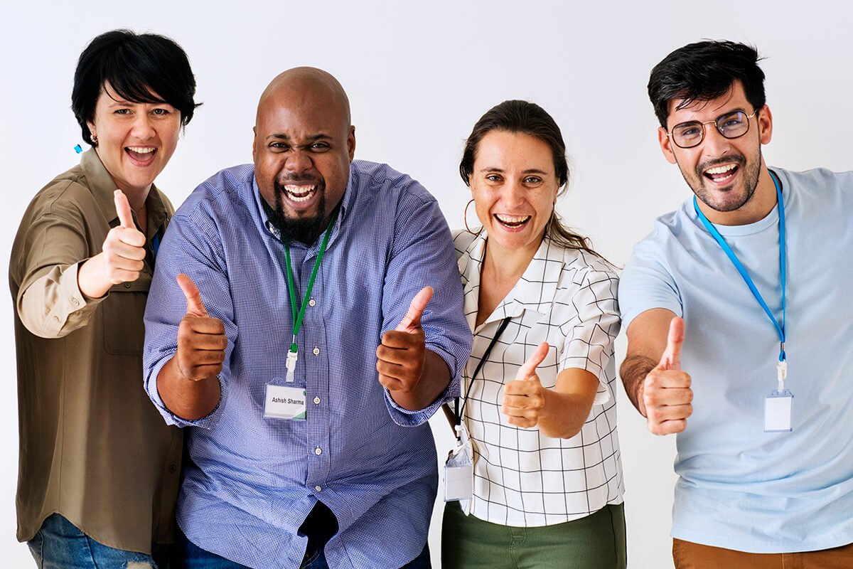 A foto retrata colegas de trabalho sorridentes, fazendo o gesto de 'ok' com as m&atilde;os para representar os benef&iacute;cios oferecidos pelo endomarketing, uma estrat&eacute;gia de marketing interna voltada para a valoriza&ccedil;&atilde;o e motiva&ccedil;&atilde;o dos colaboradores. Foto: @Freepik