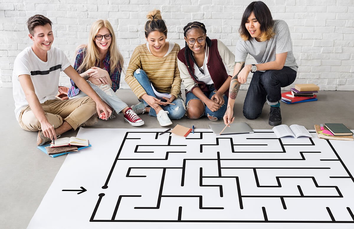 Equipe solucionando um enigma competitivo com o objetivo de envolver e motivar as pessoas atrav&eacute;s da gamifica&ccedil;&atilde;o. Foto: @Freepik.