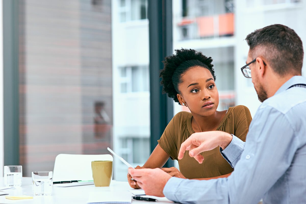 Fotografia de um chefe conversando com sua colaboradora sobre o trabalho, exemplificando a implementa&ccedil;&atilde;o do endomarketing atrav&eacute;s da habilidade de ser um bom ouvinte. Foto: @Freepik.