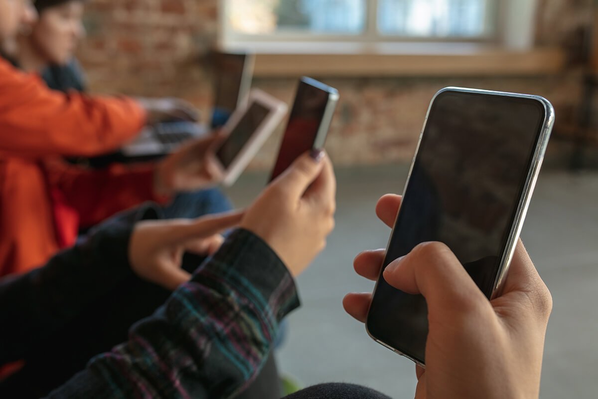 M&atilde;os de pessoas lado a lado utilizando aparelhos celulares, demonstrando o desenvolvimento de habilidades de influ&ecirc;ncia no dia a dia por meio de treinamento. Fonte: @Freepik