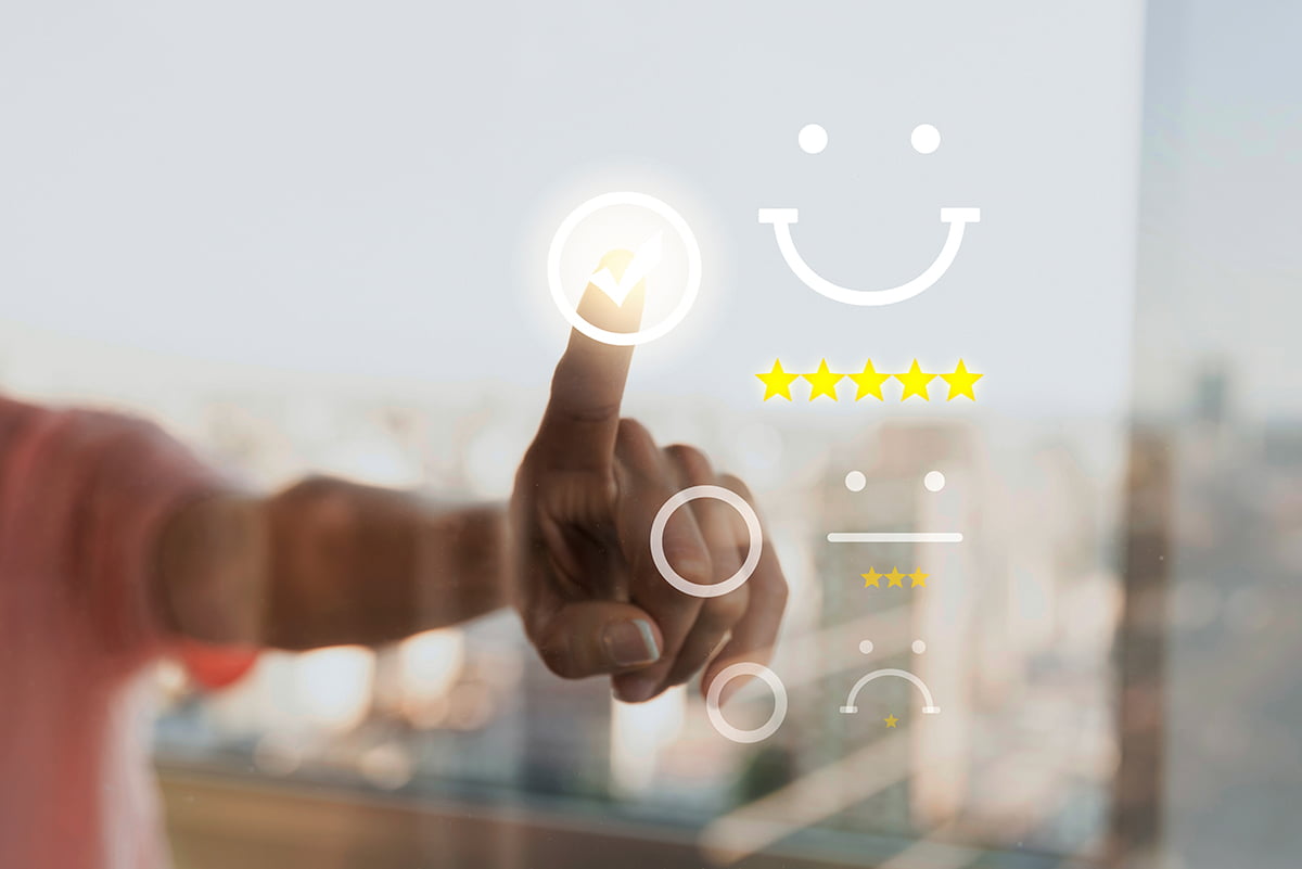 M&atilde;os de um homem clicando no invis&iacute;vel, qualificando um servi&ccedil;o como 5 estrelas e um sorriso, representando um dos benef&iacute;cios da gamifica&ccedil;&atilde;o, que &eacute; a melhora na intera&ccedil;&atilde;o entre empresas e influenciadores. Foto: @Freepik.